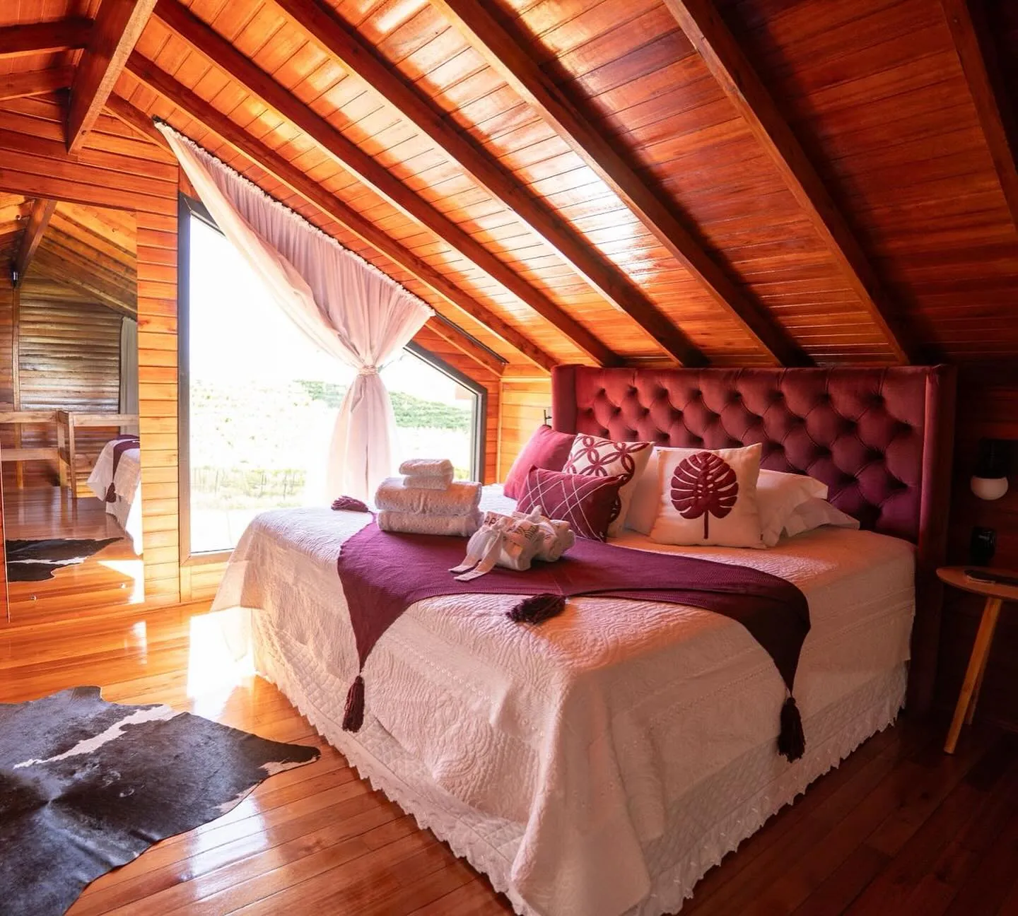 Quarto com cama de casal e janela para o verde